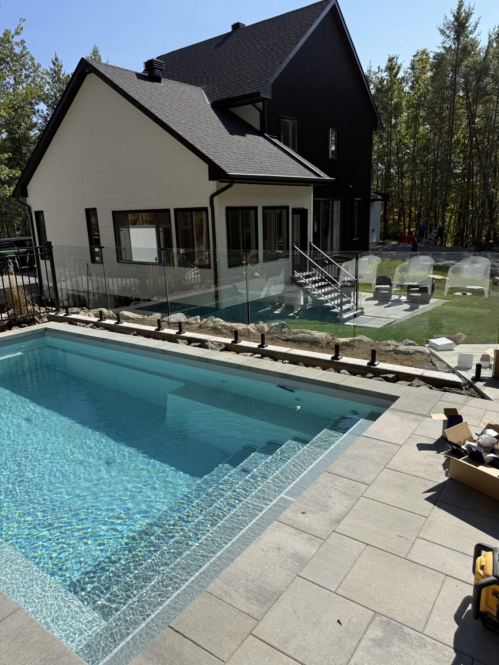Inground pool with glass fence and patio